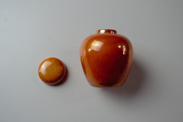 Discover our 1913 Ruskin pottery orange lustre ginger jar. Just 9cm high and 7cm wide. Add this exquisite piece to your collection today!