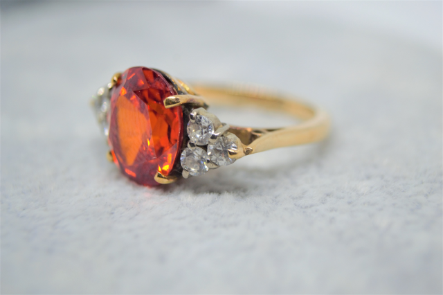 A 9ct Yellow  Gold And synthetic Orange spinel and White Sapphire Dress Ring. 