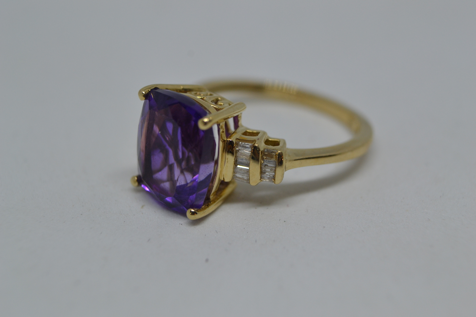 Discover our stunning 9ct gold ring, boasting a beautiful cushion cut amethyst and brilliant diamonds. Perfect fit with size M. Shop now to add elegance to your collection!