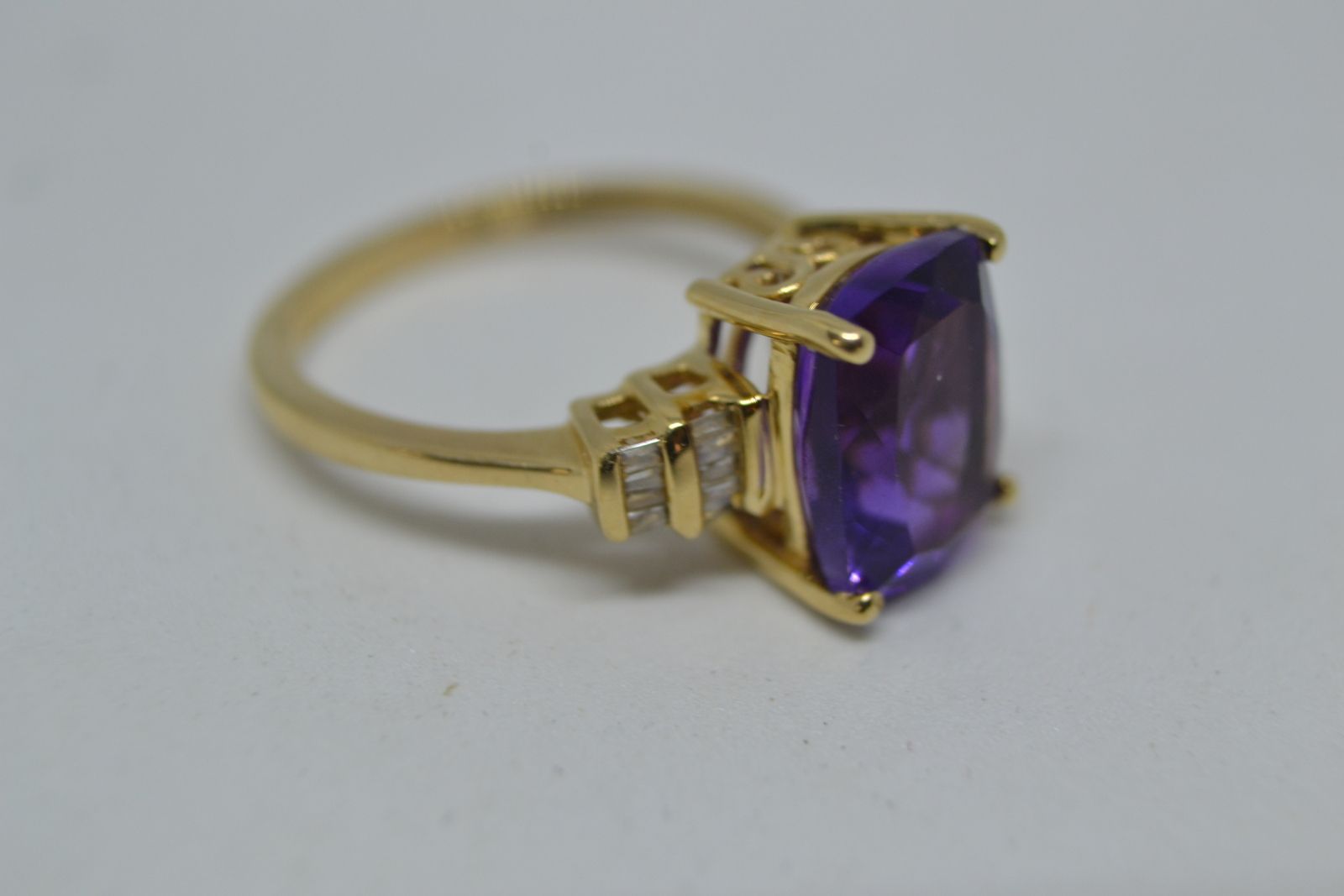 Discover our stunning 9ct gold ring, boasting a beautiful cushion cut amethyst and brilliant diamonds. Perfect fit with size M. Shop now to add elegance to your collection!