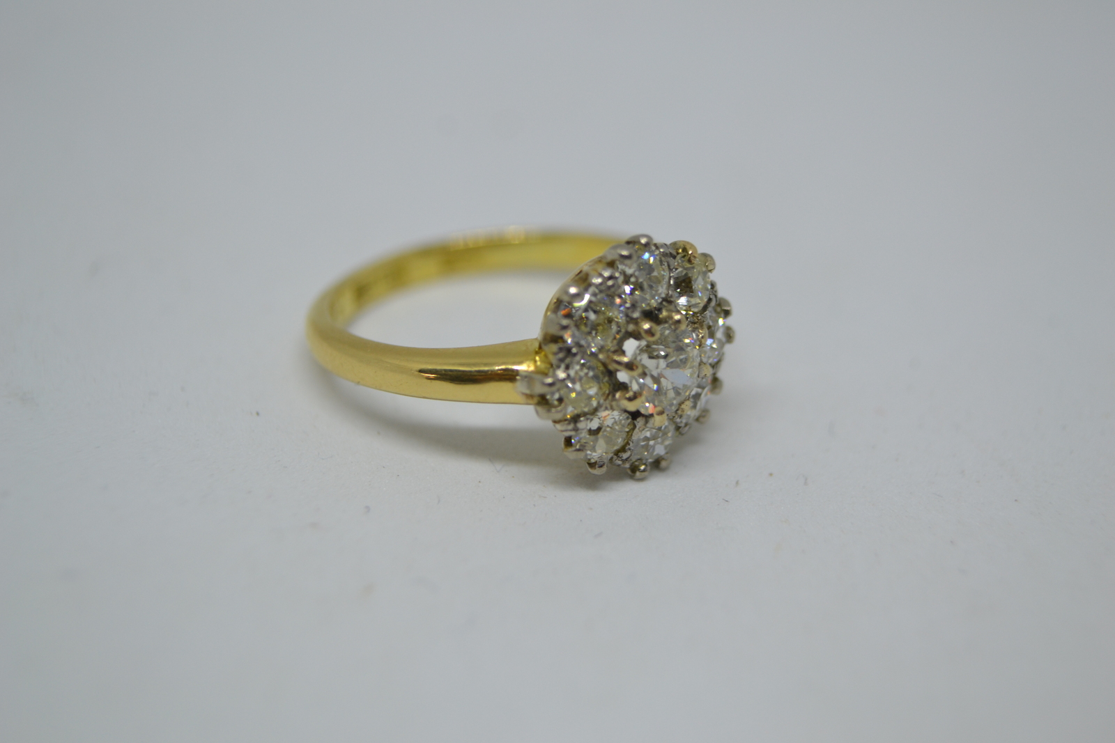 Discover our 18ct yellow gold ring featuring a diamond flower head cluster. With 9 brilliant old cut stones totaling a 1.00ct weight. Delve into diamond clarity s11/s12, colour i/j. Shop now!