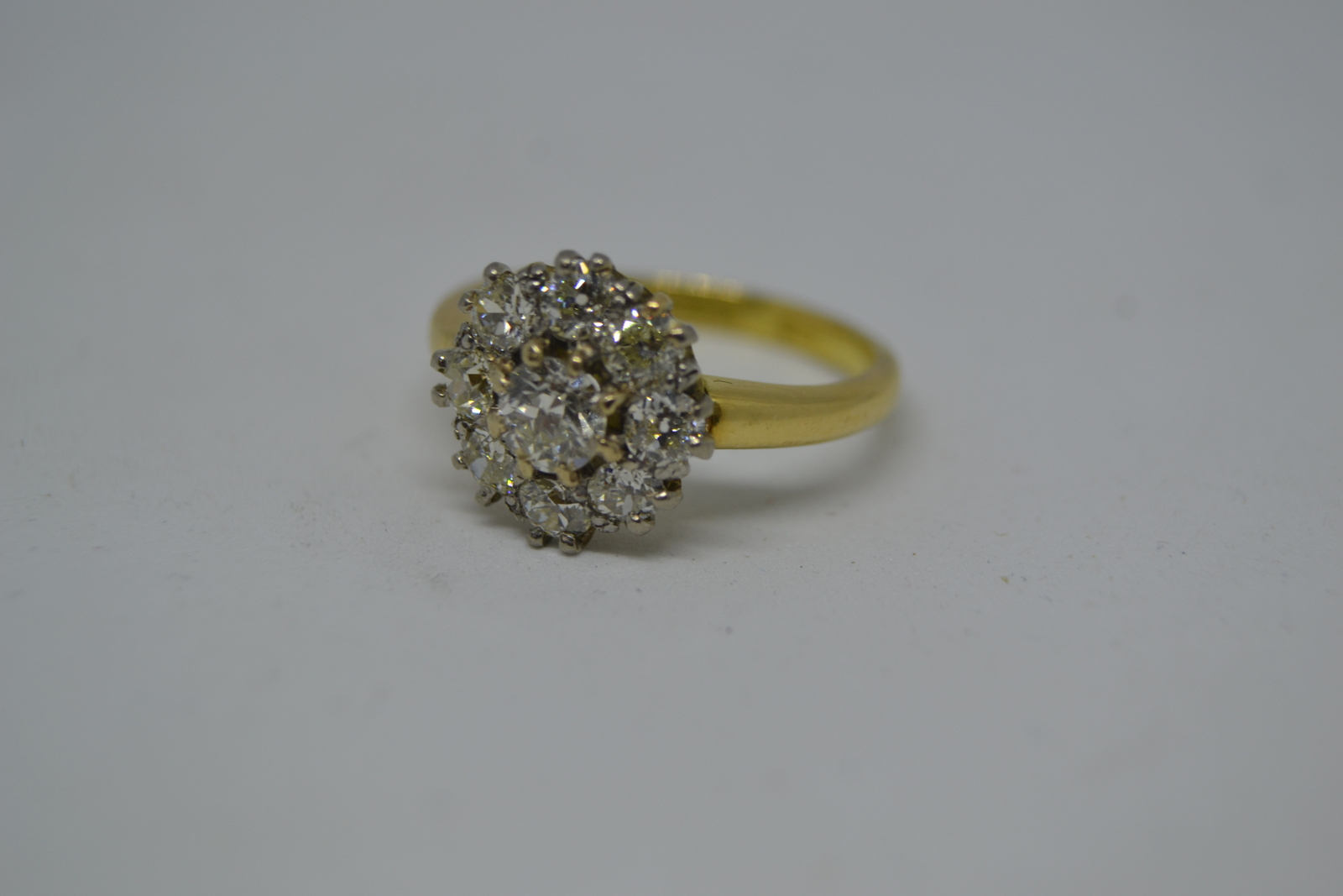 Discover our 18ct yellow gold ring featuring a diamond flower head cluster. With 9 brilliant old cut stones totaling a 1.00ct weight. Delve into diamond clarity s11/s12, colour i/j. Shop now!