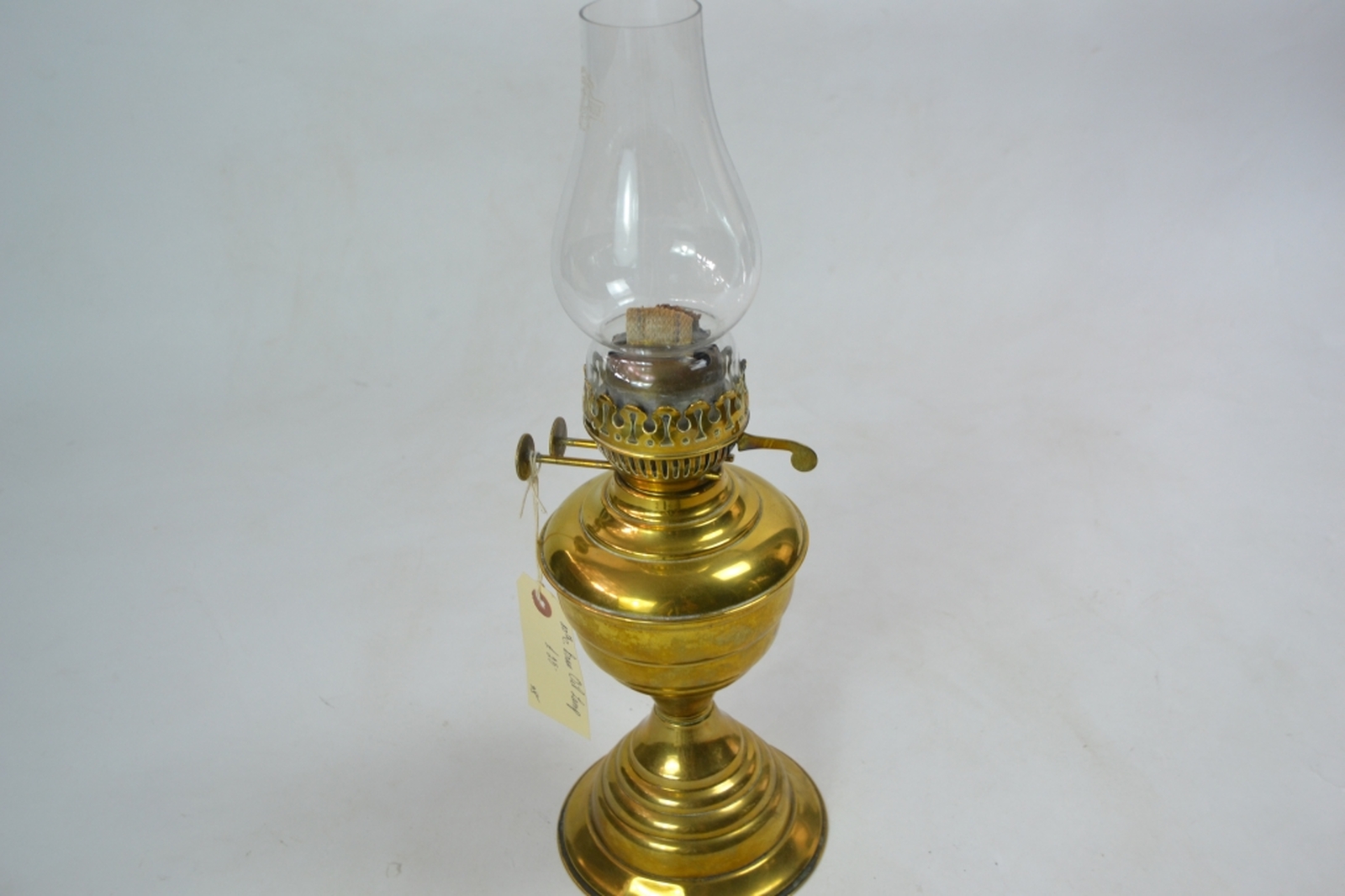 Brass oil lamp early 20th century of lobed baluster form with a typical plain glass chimney