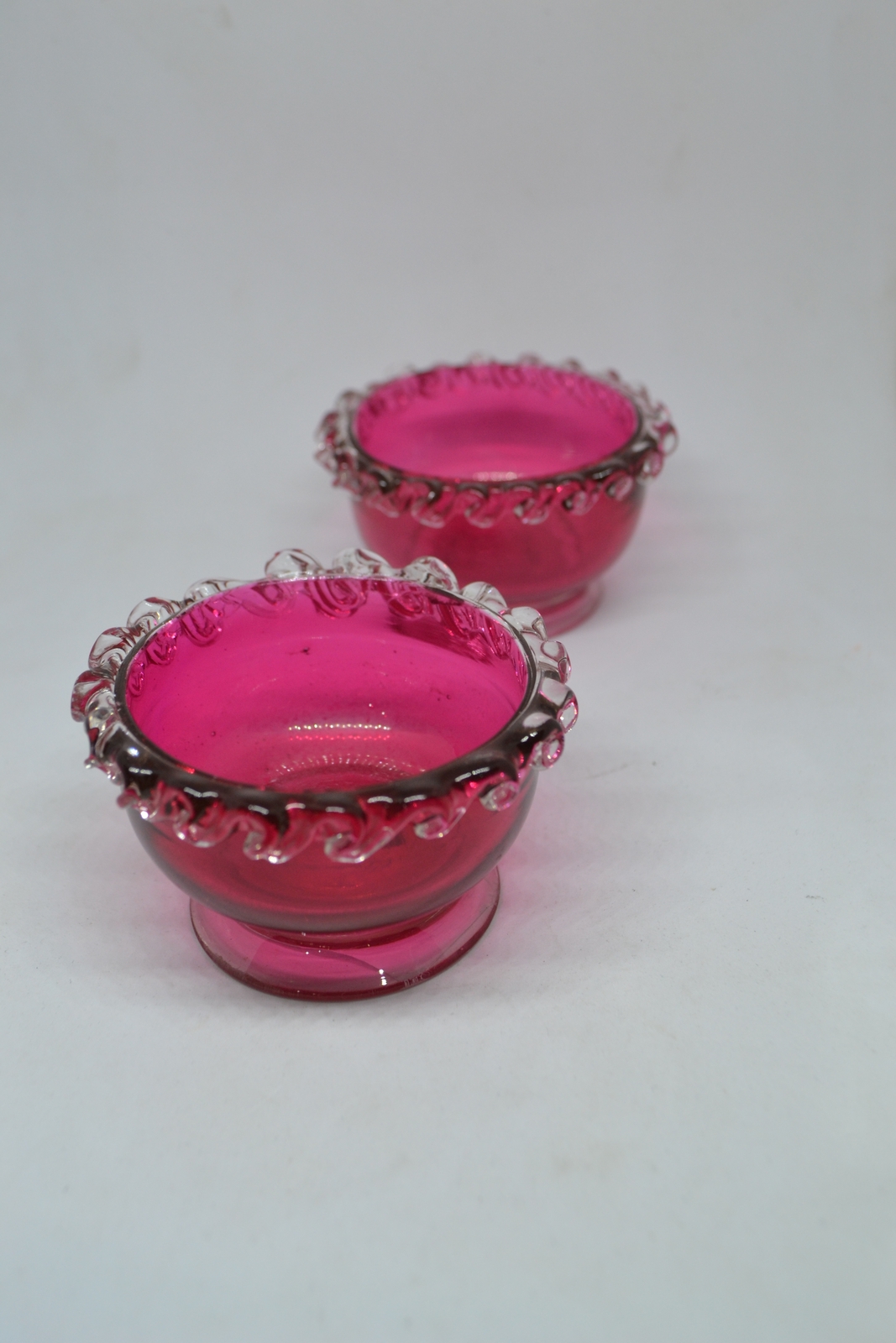 Discover our unique collection of 19th century cranberry salts. Each piece boasts intricate designs and rich color. Shop now for vintage tableware!