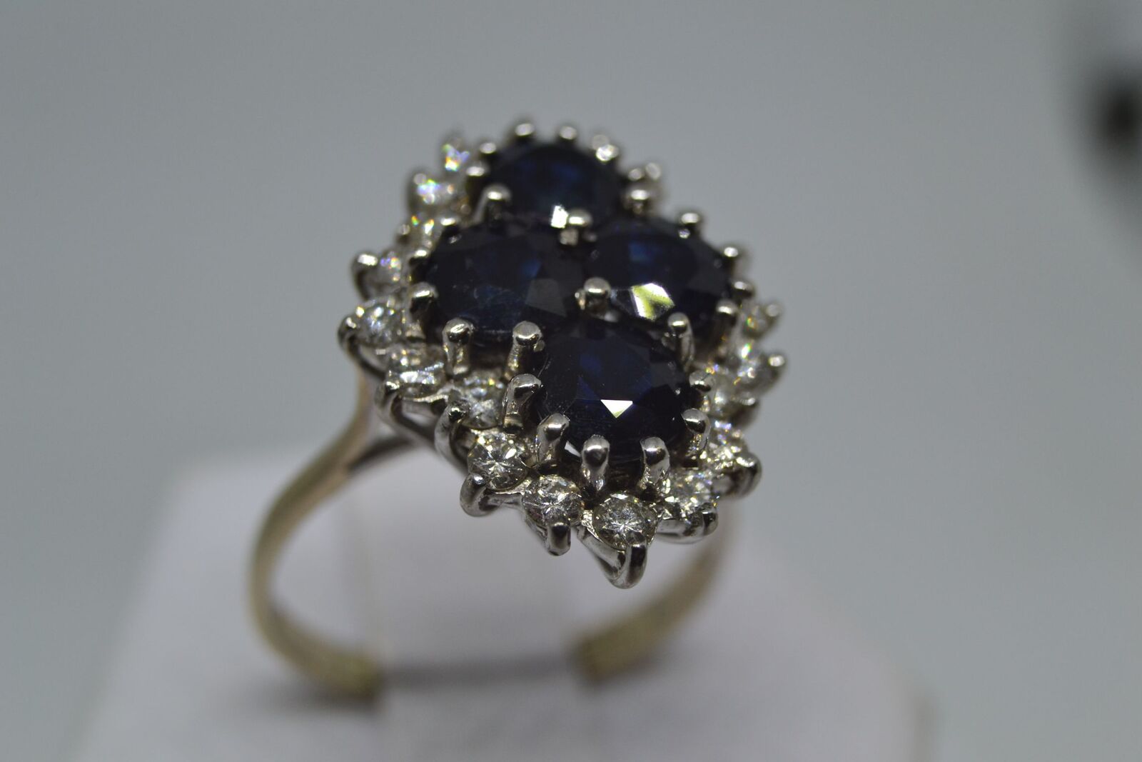 Discover our 18ct white gold sapphire and diamond cluster ring. Quatrefoil design, brilliant cut diamonds, vintage. Perfect for your special occasions. Shop today!