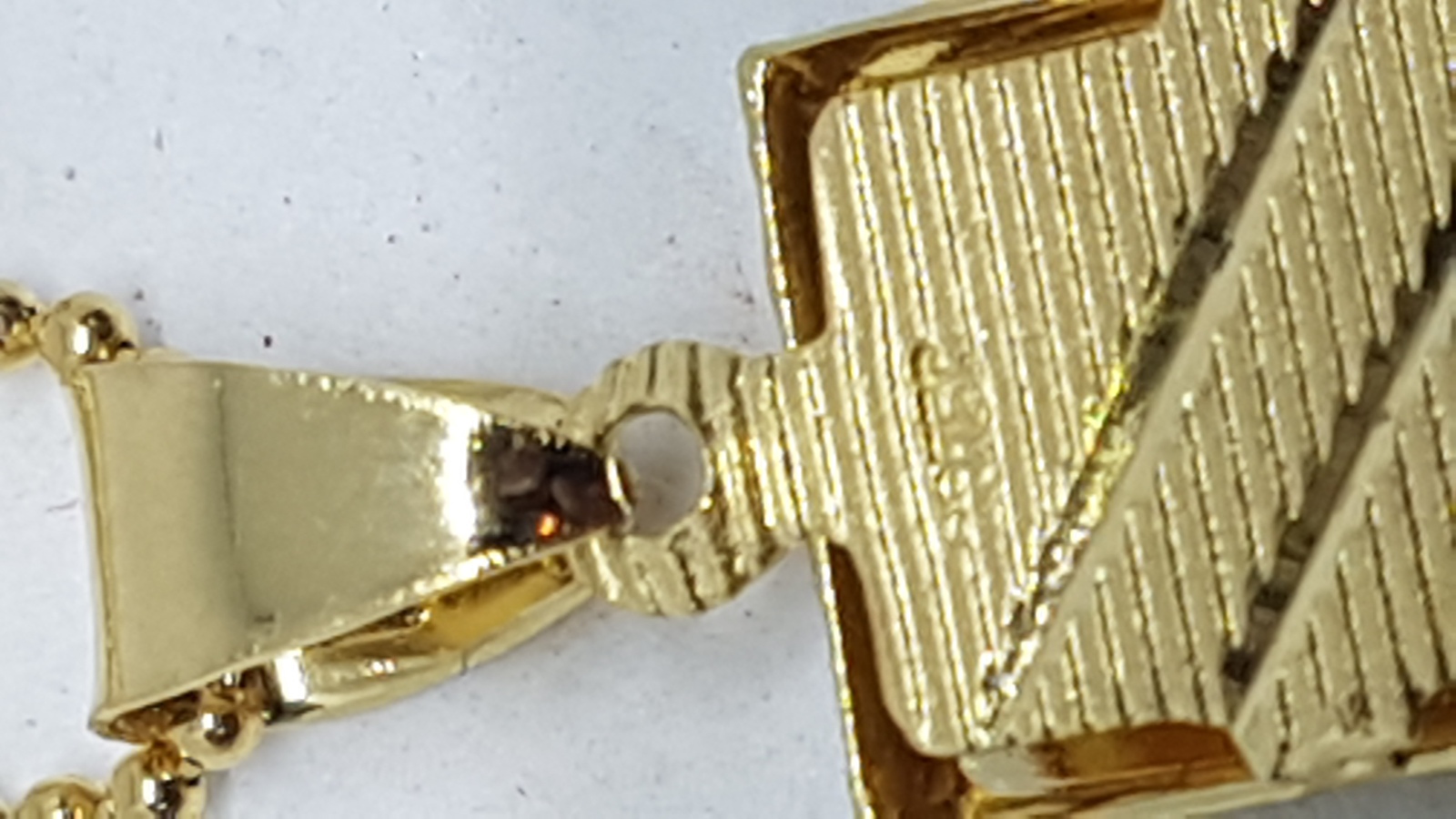 Discover our tri-coloured yellow metal pendant and earring suite. Textured with white and rose accents, it's a luxurious addition to any outfit. Explore now for a unique style boost!