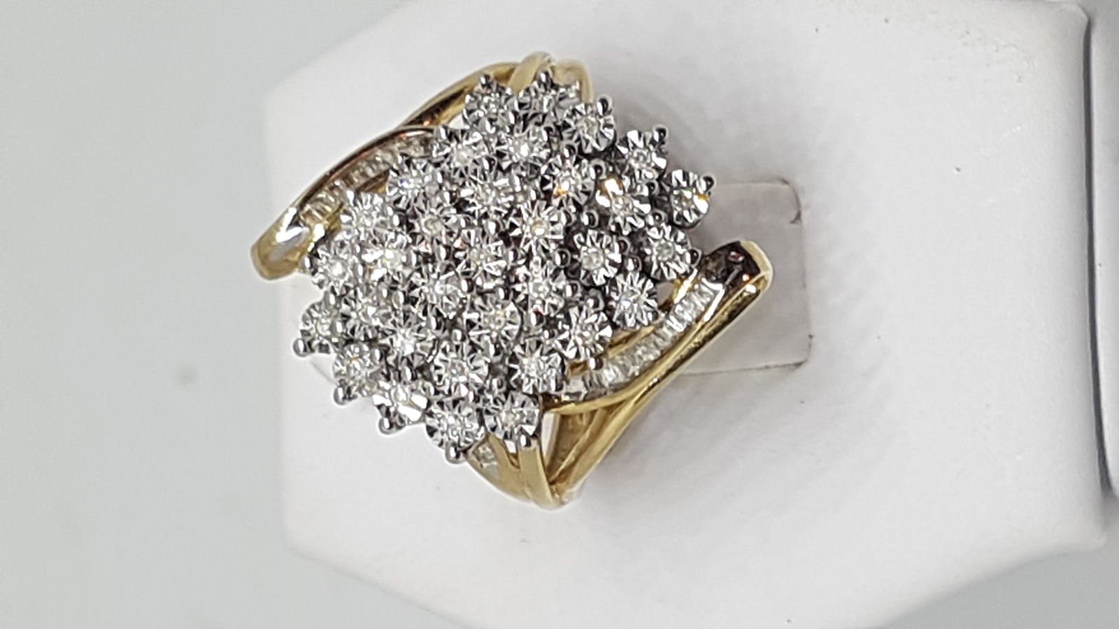 Discover our 10 ct gold and diamond cluster ring. Designed with floral sprays on a pierced mount, it's the perfect size N. Explore now and feel the weight of 4.4g luxury!